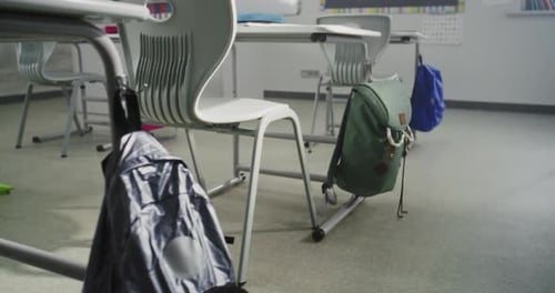 Interior of Empty Classroom with Desks School Supplies for Students and Hanging Backpacks