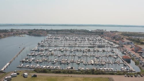 Drone cinéma/Panorama aérien encerclant un port de plaisance /port avec des voiliers par une journée ensoleillée