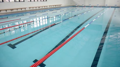 Empty indoor swimming pool with lane dividers, ready for competitive swimmers, copy space