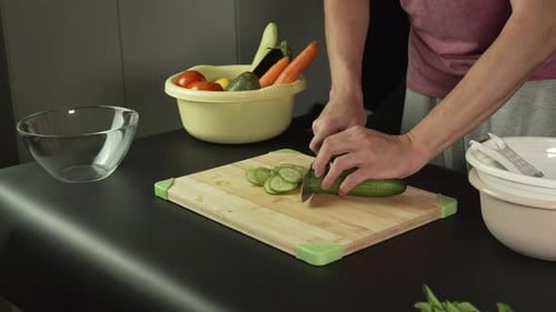 Adult Slicing Cucumber for Salad in Kitchen