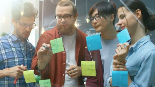 Team of Young Creative Developers Works Hard on the New Project, Drawing Plan and Highlighting it W