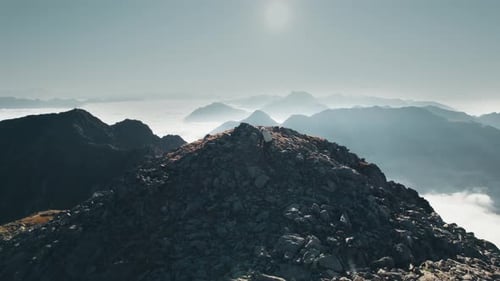Female hiker with a big backpack, going uphill and enjoying the view in the Italian Alps.