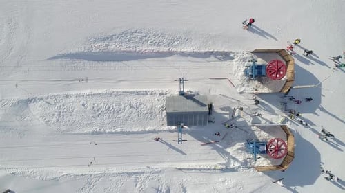 Aerial Top Down View of a Ski Lift Bottom Station Lift Wheels are Spinning Skiers Going Up By Ski