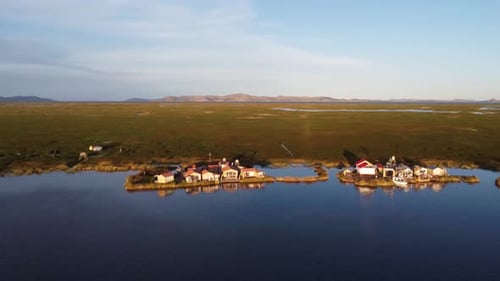 A village on a floating island on Lake Titicaca Peru, mountains in background. Alternative off grid