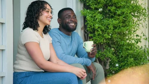 Smiling Couple Relaxing on Porch Drinking Beverage