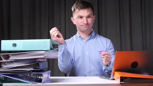 Man at Desk pops Balloon with Pin