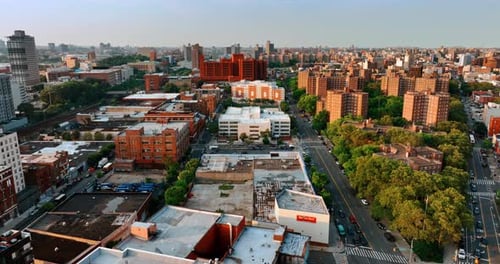 Diverse blocks of flats in the cityscape of New York. Drone footage above the roofs at sunset.