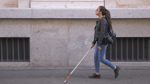 Blind young woman walking with stick in the city.Blindness,autonomy