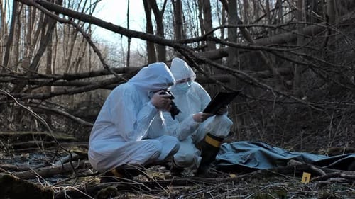 Forensic Specialist Working in the Forest Police Criminalists Collecting Evidence and Making