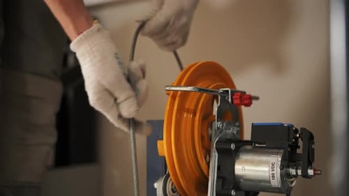 Technician Connecting Metal Cable to an Industrial Machine