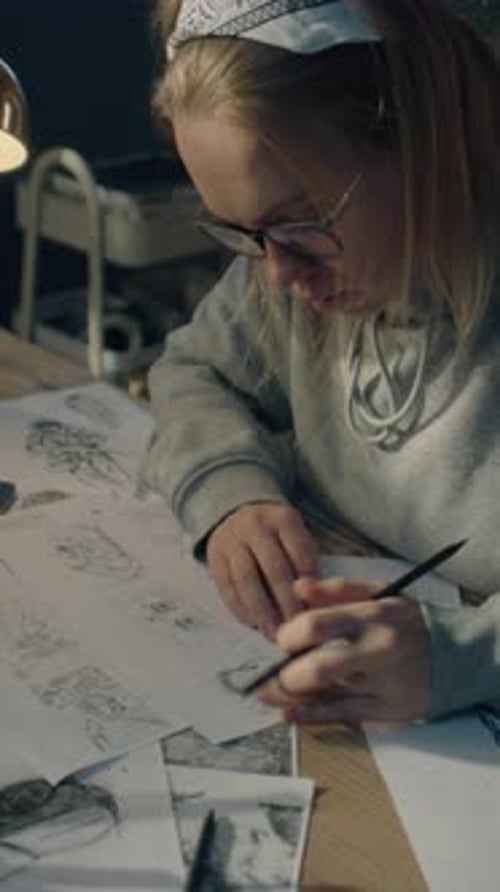 Young Woman Drawing Storyboard Panels at Night