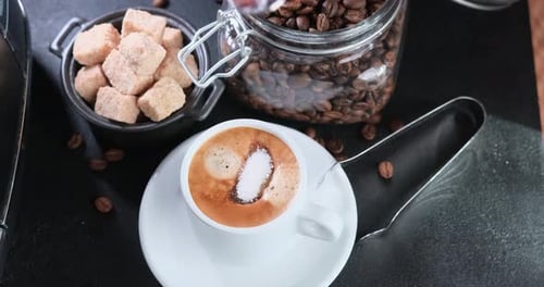 Adding Sugar into Hot Cup of Coffee