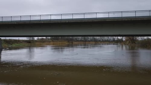 Luftaufnahme von Hochwasser im Frühling, Überschwemmung des Flusses Barta (Lettland), brauner und schlammiger Weg
