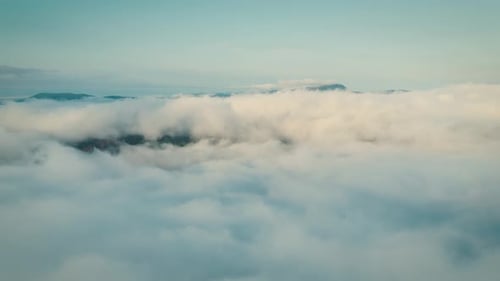 Aerial View of Mountains Emerging From Clouds