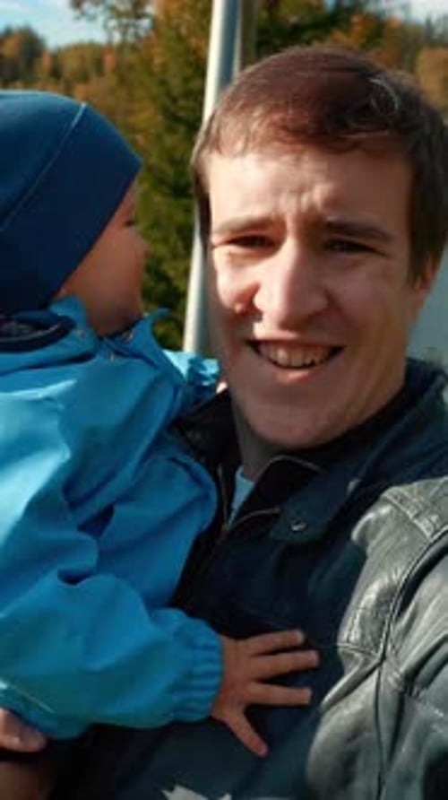 Dad Holding Adorable Child Outside on Sunny Day