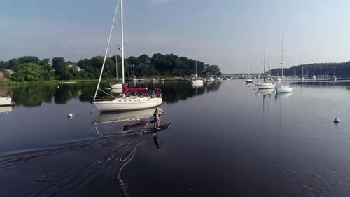 Paddleboarder paddling away in a harbor.