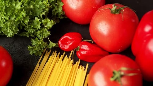 Tomatoes with Parsley and Pasta on a Black Background
