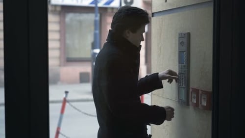 Young teenage boy inputs security code to enter modern apartment building