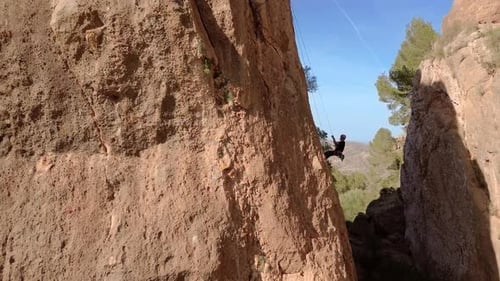 Man rock climbing aerial view of sportsman rapelling mountain in La Panocha, el Valle Murcia, Spain