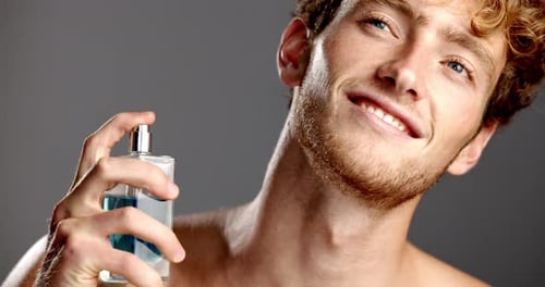Happy, cologne and man in studio, cosmetics and smell with confidence on gray background