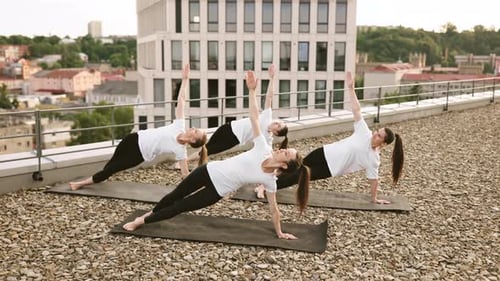 Women Doing Yoga on Rooftop in the City