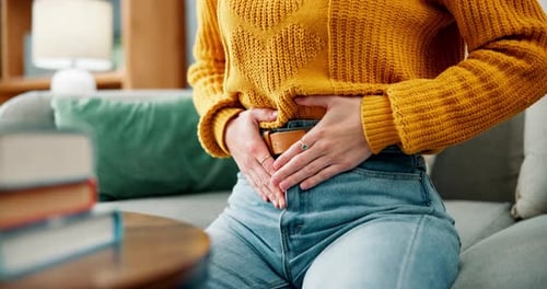 Stomach, pain and woman hands in home with abdomen, belly and sick from constipation