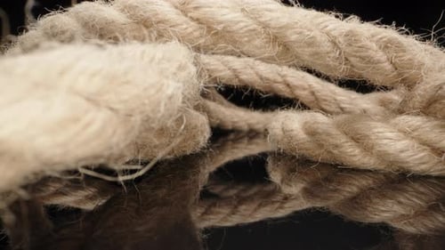 Jute rope on black table. Dolly slider extreme close-up. Laowa Probe