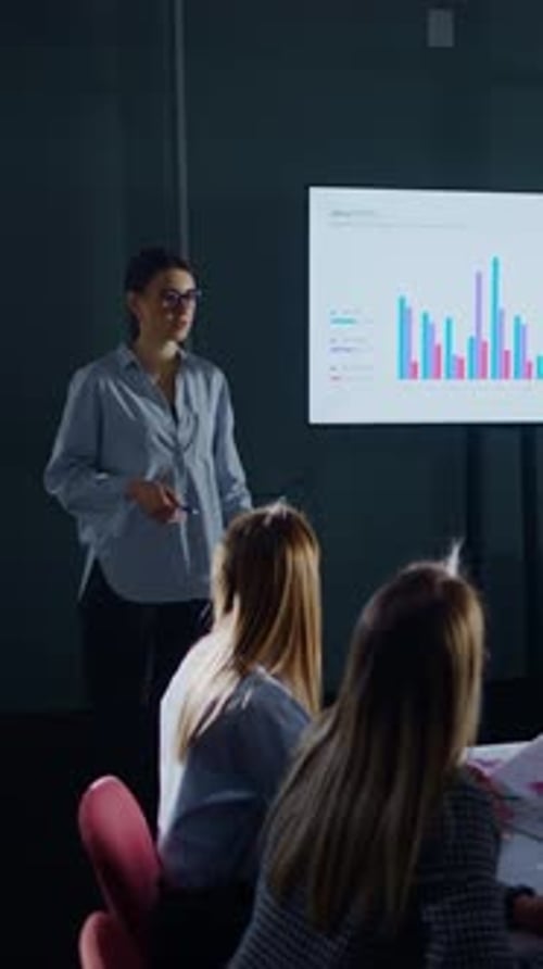 Woman Presents Business Analytics to Colleagues in Office