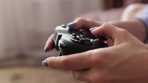 Hands Holding and Using Game Controller Close-Up
