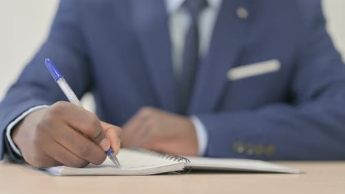 Close up of African Businessman Writing in Office