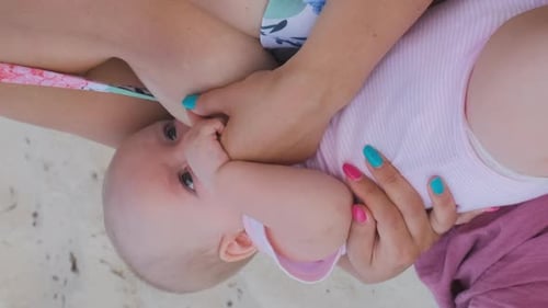 Bebé chupando leche del pecho de su madre en vacaciones