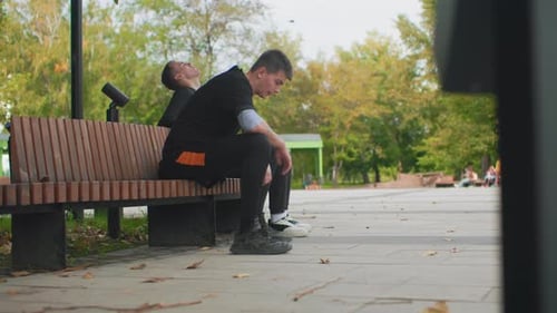 Lässiger Chat im Stadtpark Sanfte Unterhaltung zwischen Männern auf dem Sunny City Square Zwei Männer teilen