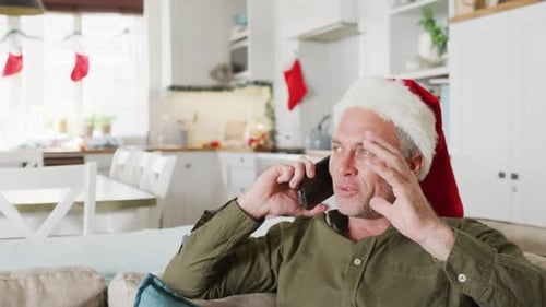 Man in Santa Hat Talking on Phone at Christmas
