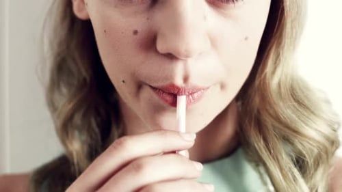 Young Woman Sipping Drink Through Pink Straw