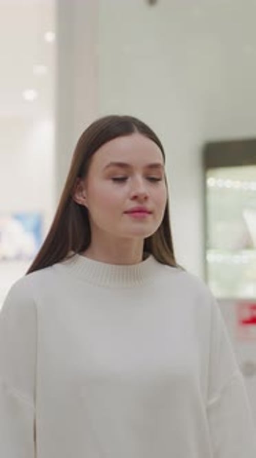 Girl Walking in White Clothes Towards Decorative Christmas Plant in Modern Shopping Mall