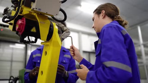 Los ingenieros inspeccionan y revisan la máquina de los robots de soldadura de máquinas de brazos automatizados en la fábrica.