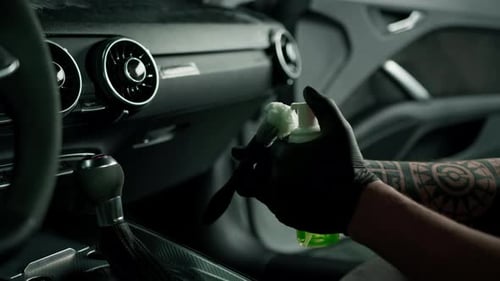 Gloved Hand Cleaning Car Interior with Foam and Brush