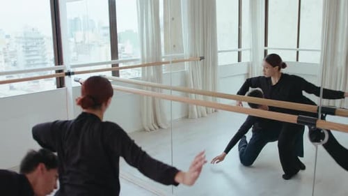 Young Couple Practicing Contemporary Dance in front of Mirror at Studio