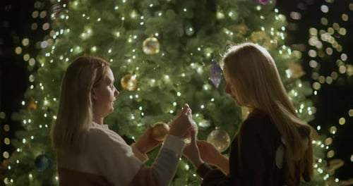 Mom and Daughter Decorate the Christmas Tree Together Christmas Eve and Cozy House