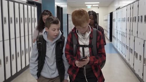 Students texting on phones in school corridor slow motion Canada