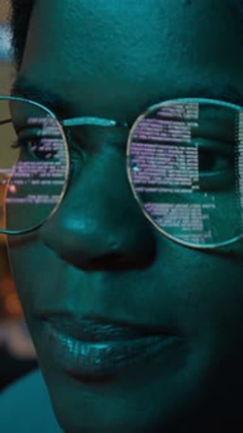 Un développeur de logiciels vertical en noir codant avec réflexion de code dans des lunettes