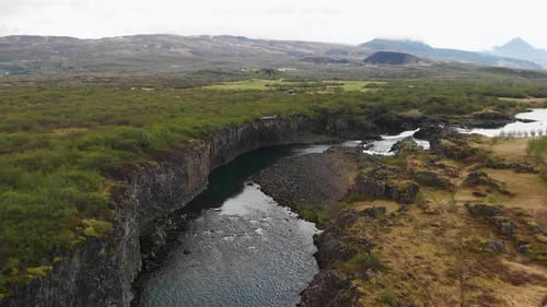Aerial footage over a beautiful river coming from the waterfall Glanni in Iceland.
