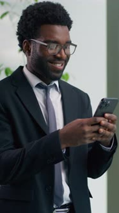 Smiling African American Businessman Using Smartphone in Office Business Man Ethnic Male Guy Looking