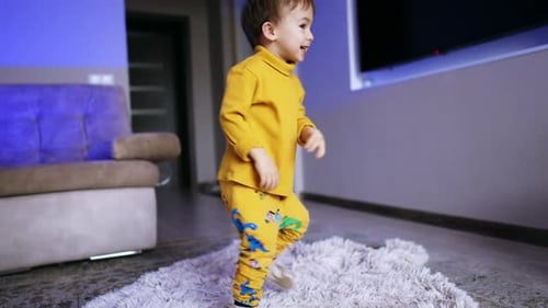 Cheerful energetic baby boy turning around. Adorable toddler having fun time at home.