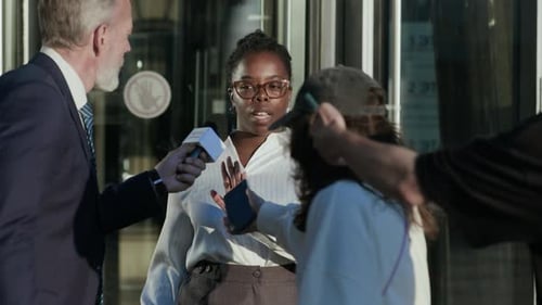 Woman Answers Press Questions Outside Building