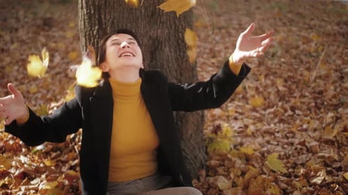 Portrait of an Attractive Woman Walking in the Autumn Park on a Sunny Day and The Smiling Face of a