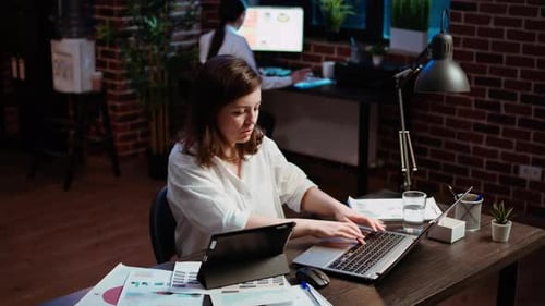 Woman Working Late with Tablet and Laptop