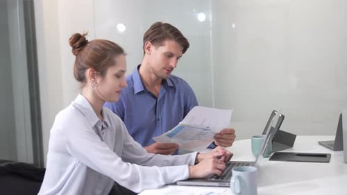 Business Colleagues Work Together on Laptop in Office