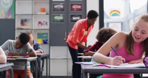 Portrait of happy diverse schoolchildren at desks in school classroom