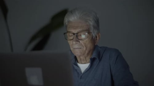 Senior Man Uses Laptop at Night